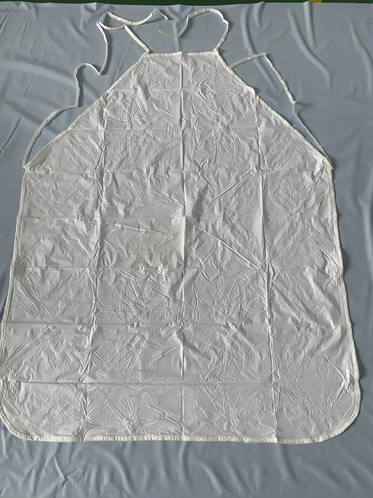Cheaper White Disposable PVC Apron Non-Woven Sewing Edge Waterproof