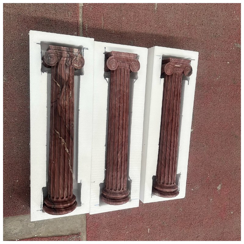 Four Carved Exotic Red Quartzite Fluted Ionic Columns