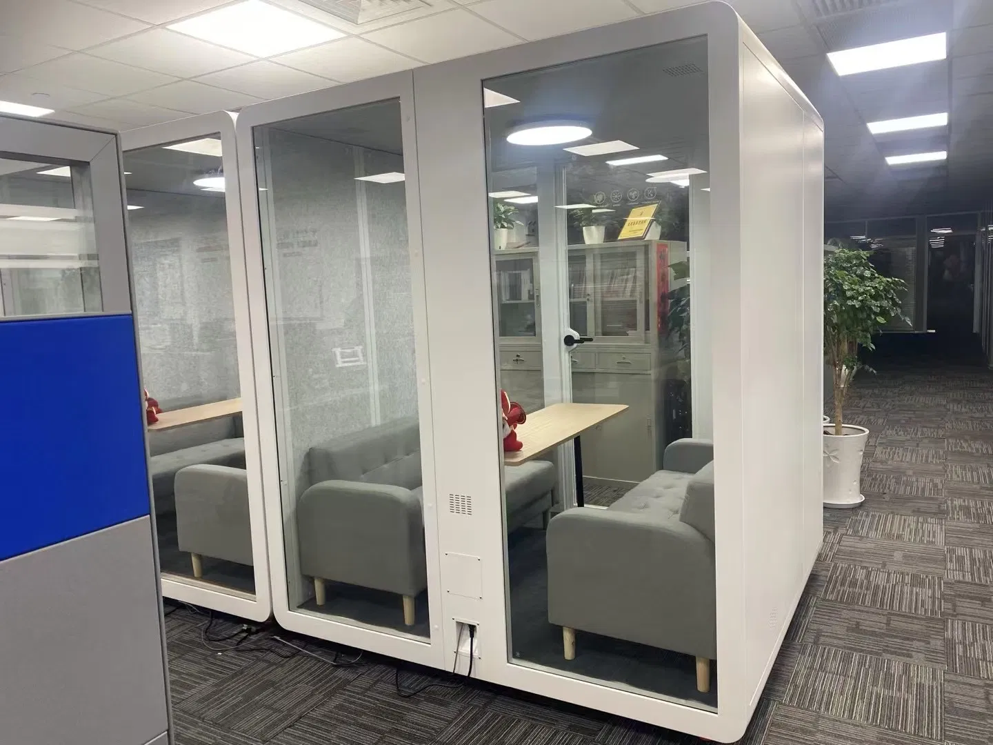 an Acoustic Booth and Office Pod Alongside a Sleeping Pod Built as a Log Cabin