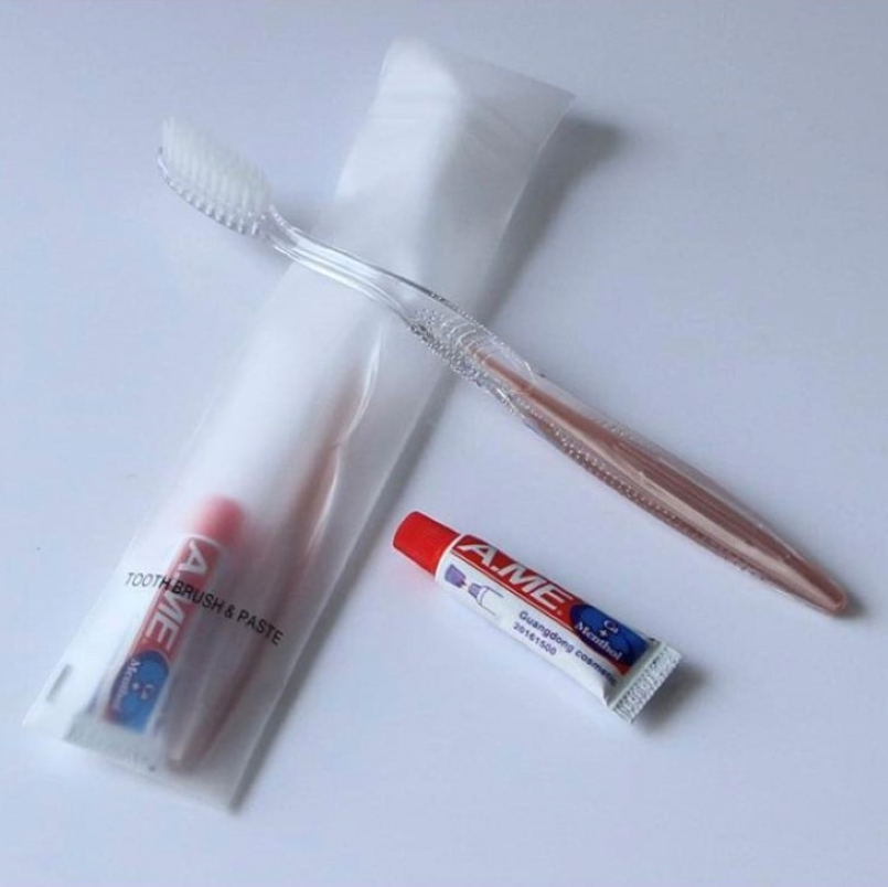 Toothbrush and Toothpaste in Plastic Packing with Hotel Amenities for Guest Room