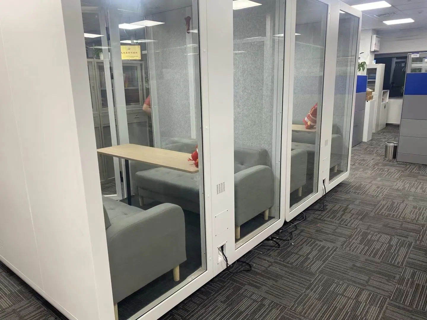 an Acoustic Booth and Office Pod Alongside a Sleeping Pod Built as a Log Cabin