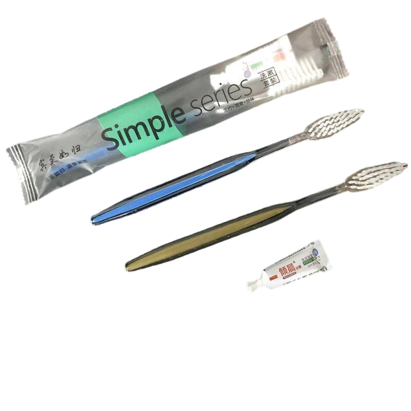 Toothbrush and Toothpaste in Plastic Packing with Hotel Amenities for Guest Room